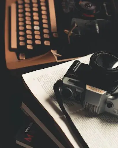 Taula amb una màquina d'escriure, papers i una càmera