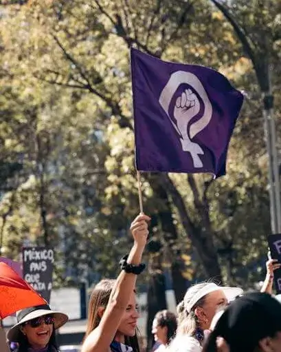 Feminisme Manifestació de dones amb la bandera feminista