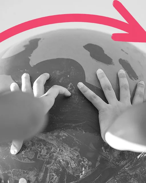 Mans fent l'acció de girar un globus terràqui