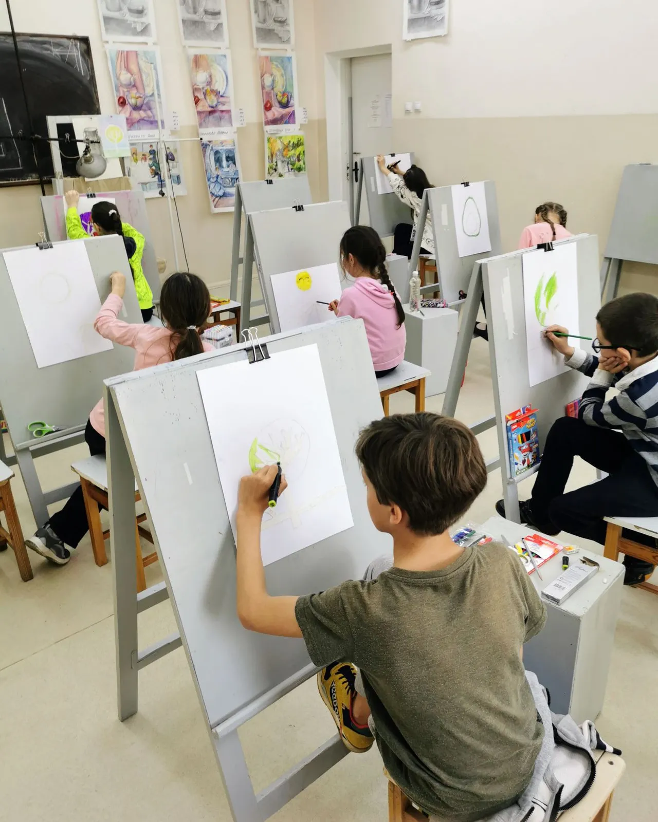 Un grup de nens participant activament en activitats de dibuix durant una classe d'art.