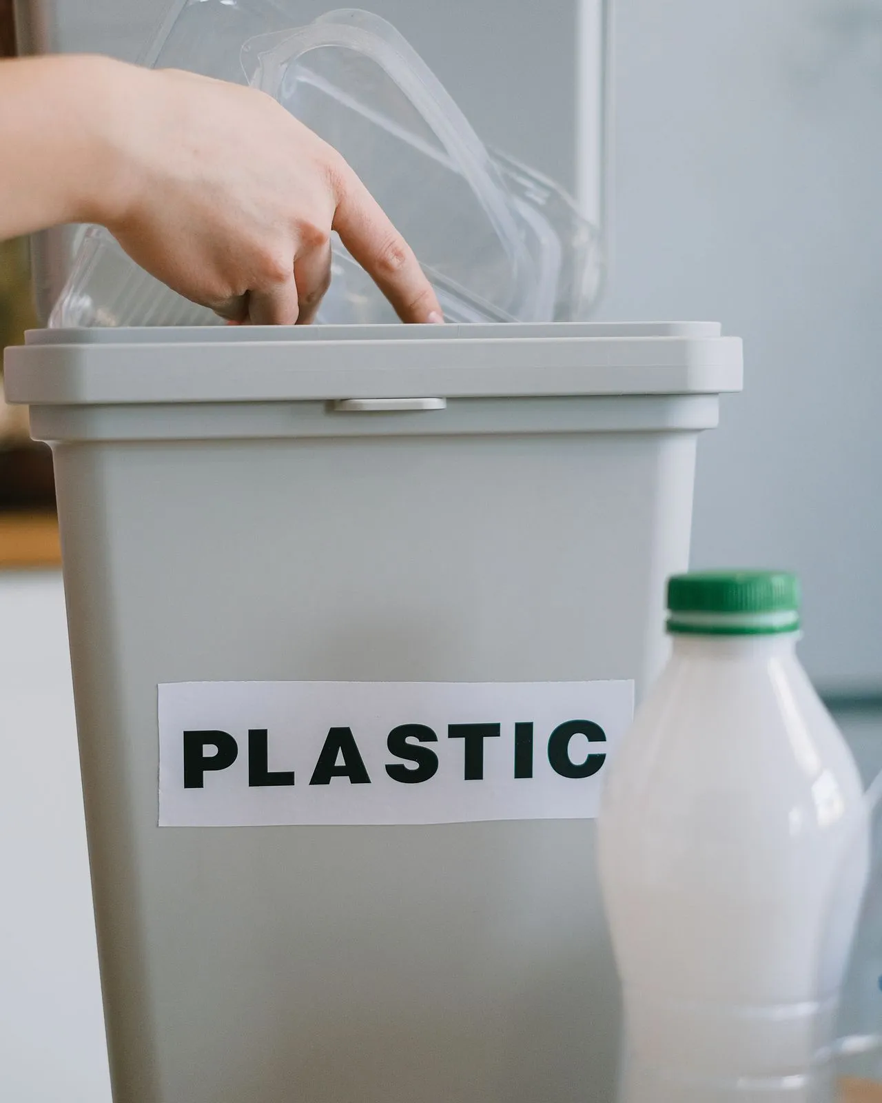 Reciclatge de plàstic amb triatge manual de residus en un contenidor etiquetat.