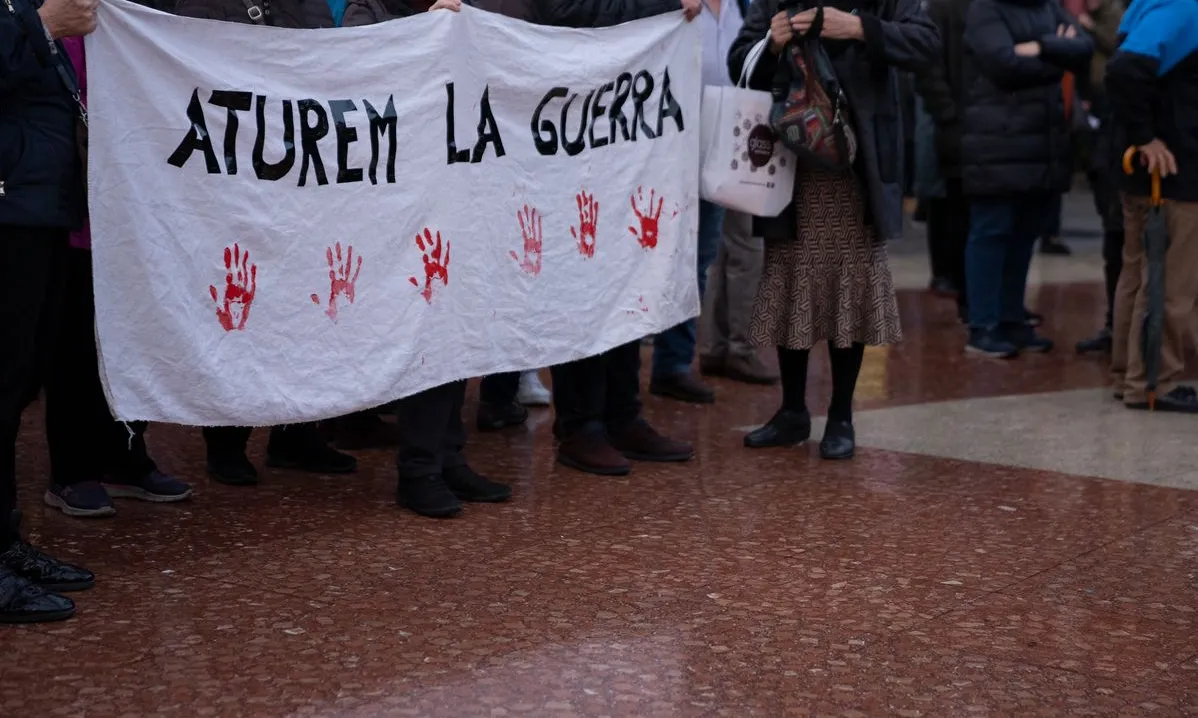 Manifestants a la plaça de Catalunya portant una pancarta per demanar la fi de la guerra d'Ucraïna
