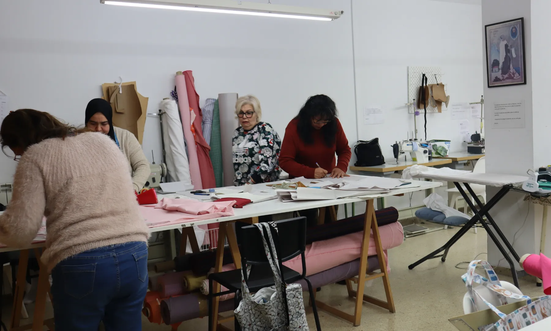 Diverses participants treballen en un taller de costura del Centre de Promoció Social Francesc Palau, on confeccionen productes tèxtils amb materials reutilitzats.