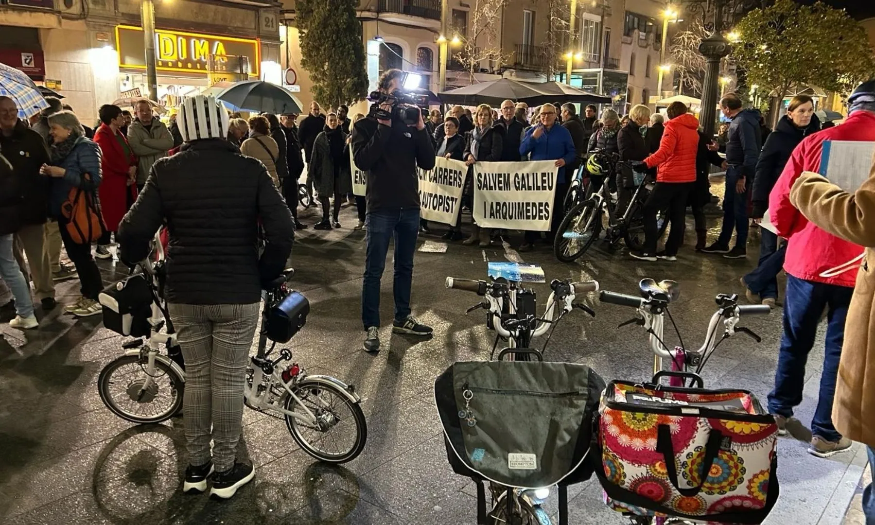Grup de persones concentrades al carrer amb pancartes de la Plataforma Salvem Galileu i Arquímedes i diverses bicicletes en primer pla.