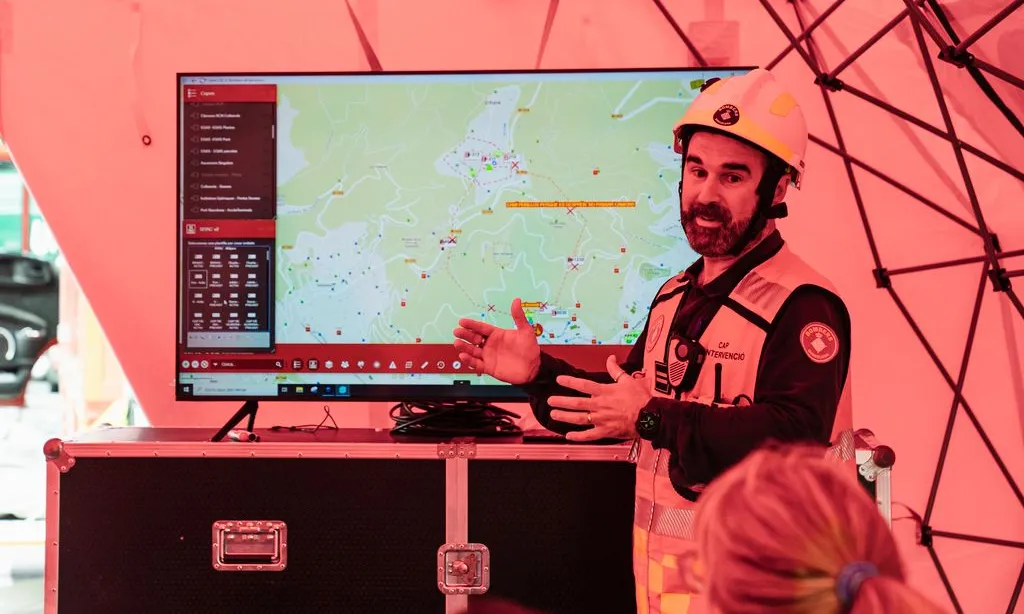 Bomber parlant davant un mapa de collserola.
