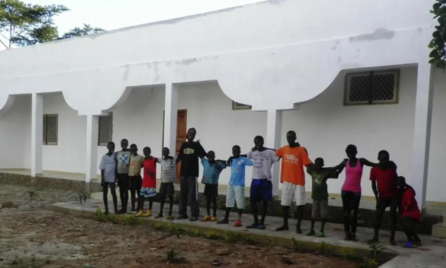 Imatge de l'Escola d'Oficis de Biombo amb els nens a l'entrada