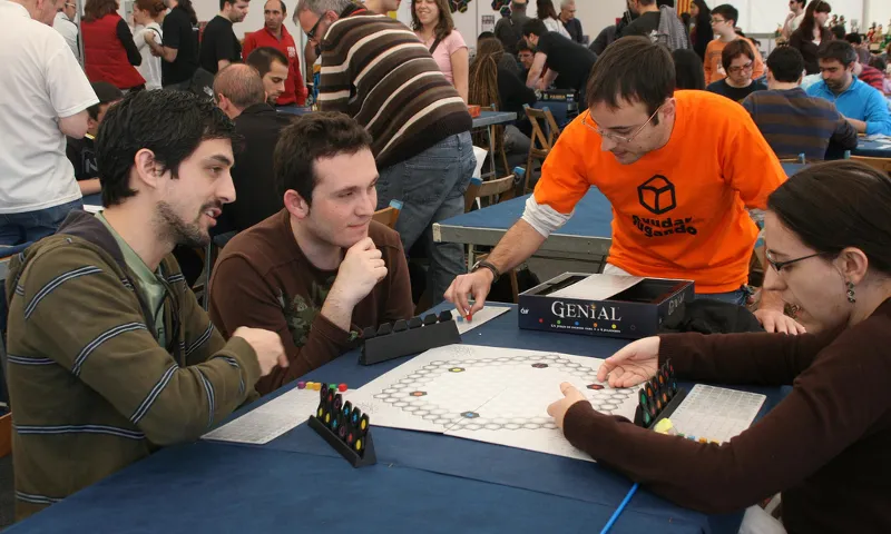 Voluntari d'Ayudar Jugando explicant el joc Genial. Foto: Flickr Ayudar Jugando