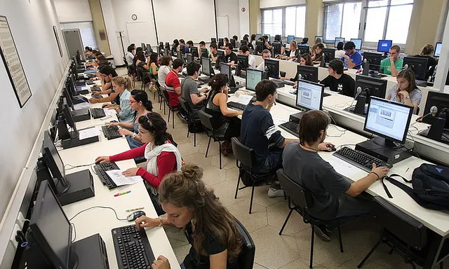 Aula d'ordinadors amb estudiants treballant-hi