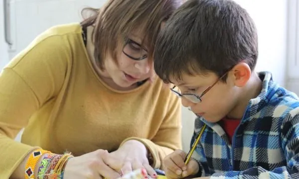 Una voluntària ajudant a llegir a un nen