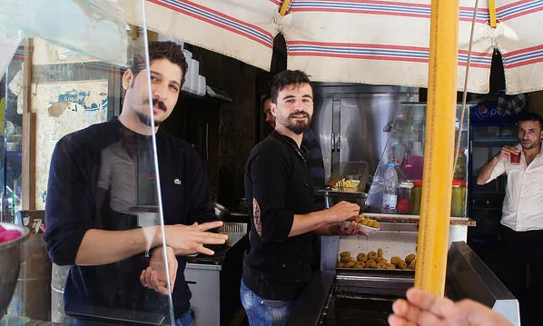 Dos joves sirians treballen en el sector de la restauració. Font: Zeinab Mohamed, Flickr