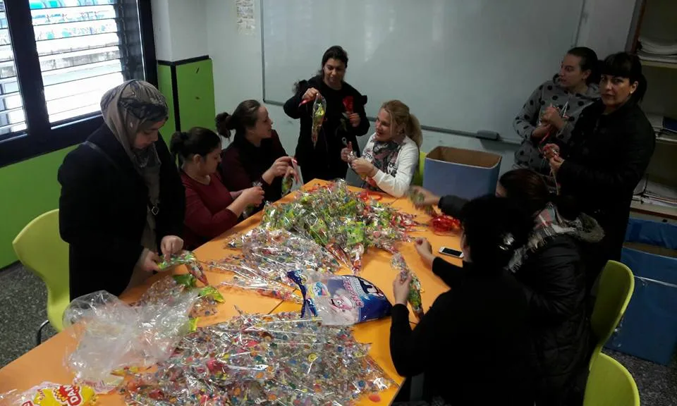 Monitors i monitores de l'esplai amb diverses mares col·laborant en els preparatius de Nadal. Font: Esplai Eixida