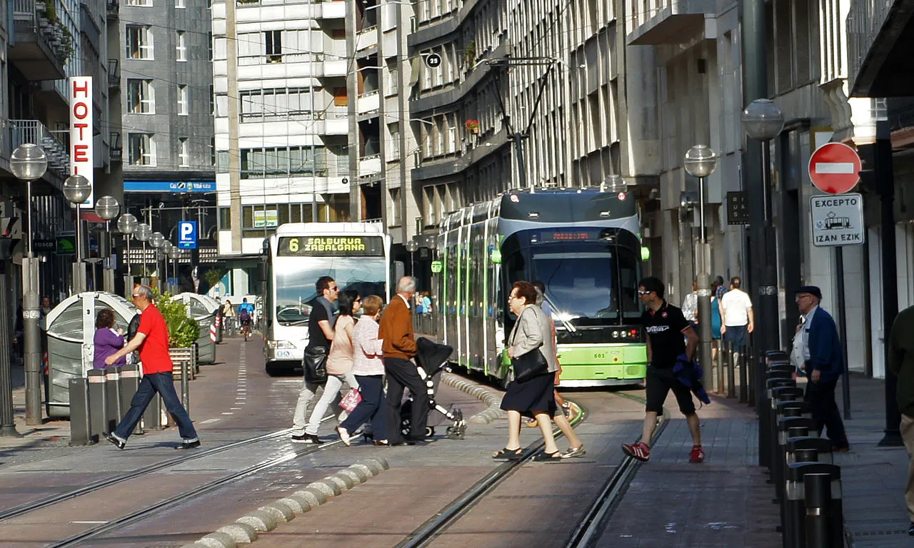 Carrer ciutat amb tramvia i bus