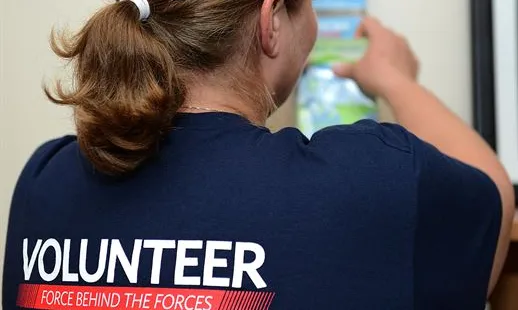 Una voluntària d'esquena mostra la seva samarreta.