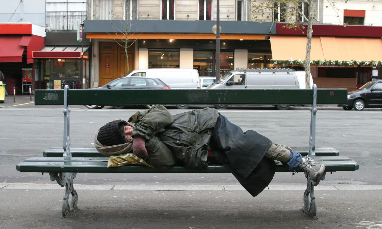 Una persona dorm en un banc