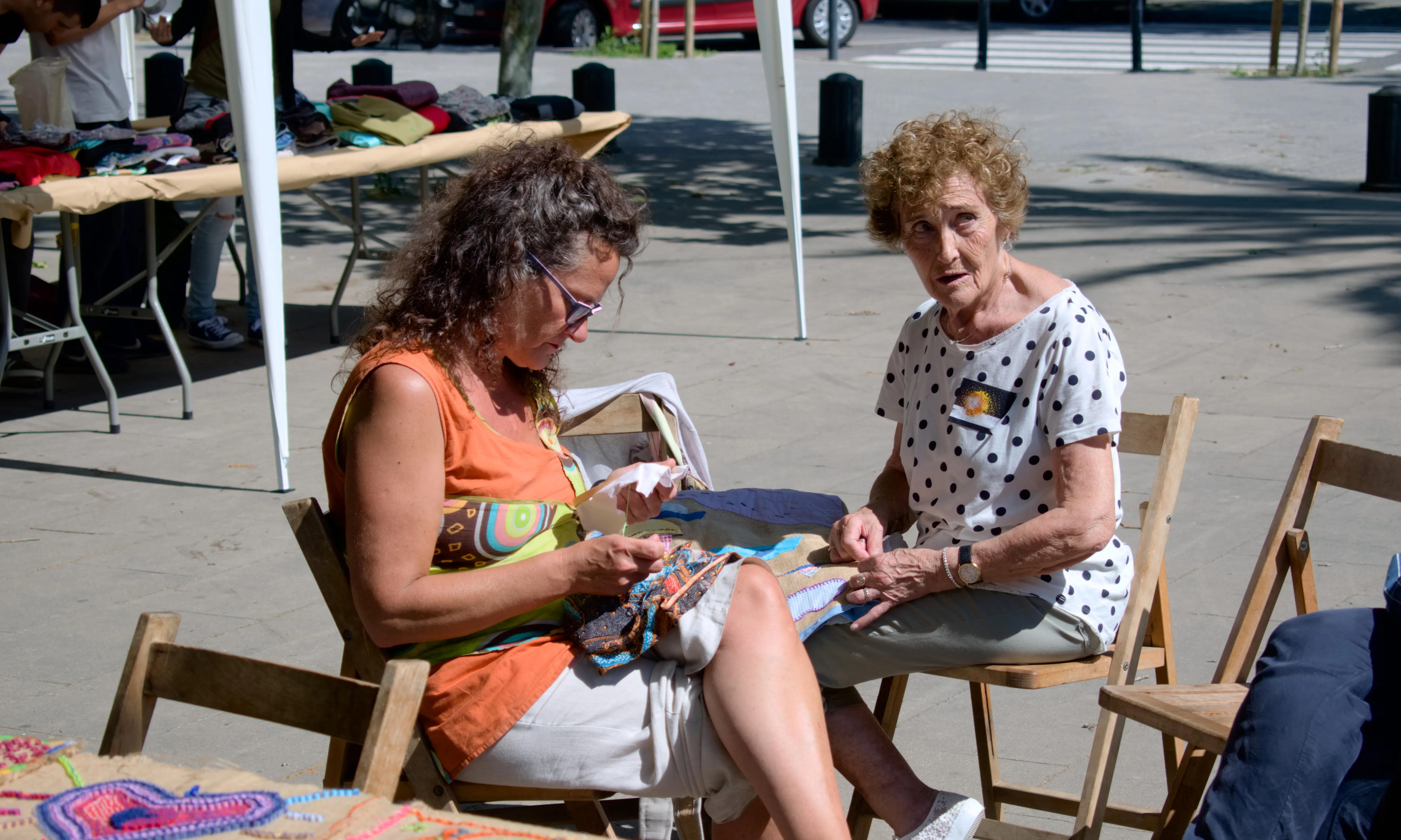 Dues dones cosint al carrer