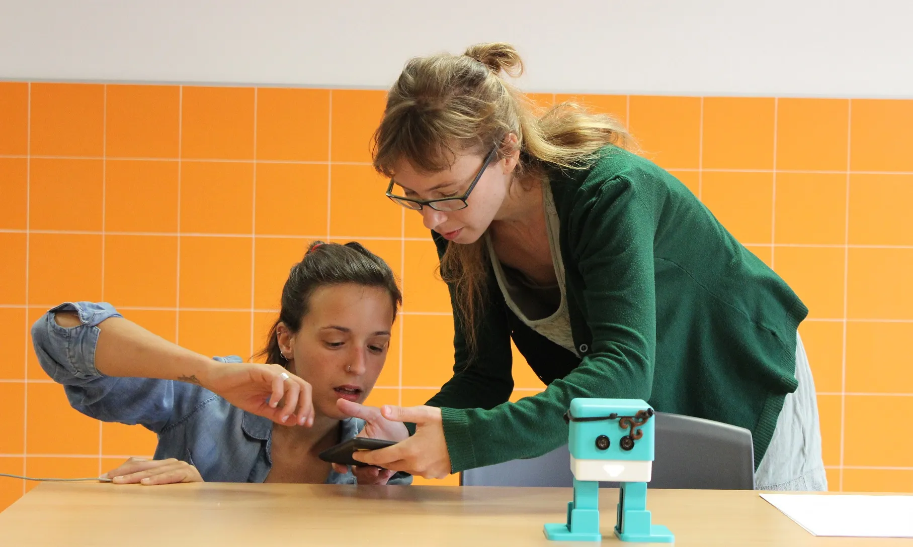 Dues dinamitzadores digitals participant en un esdeveniment de robòtica educativa