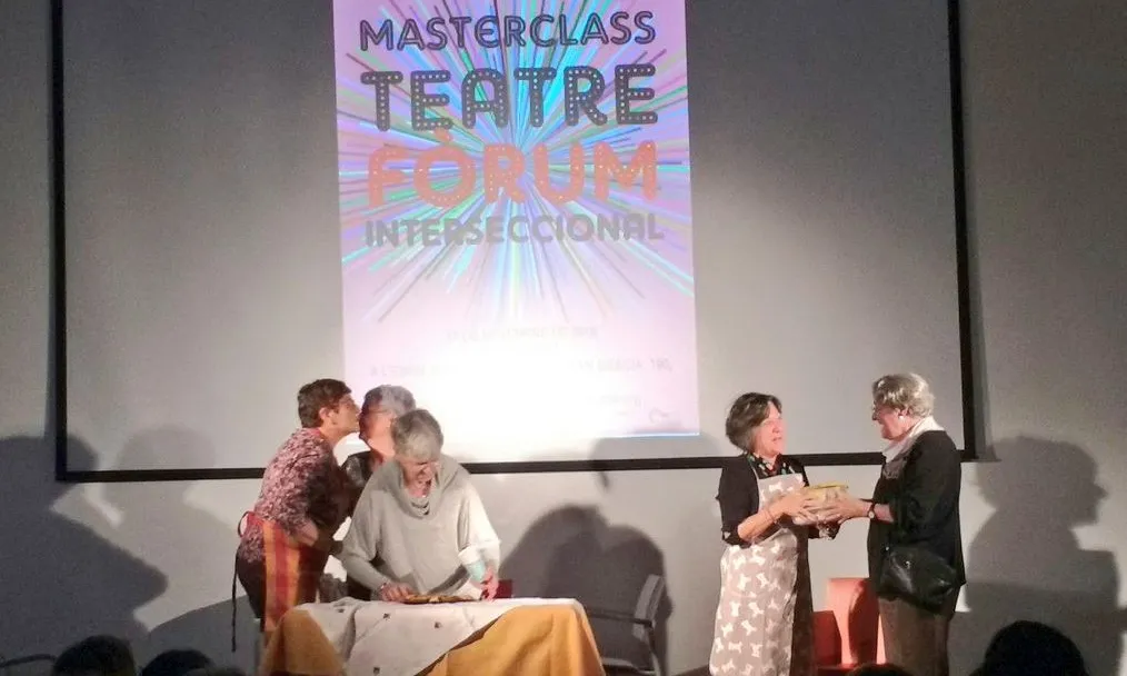 Dones a dalt d'un escenari participant d'una activitat de teatre fòrum