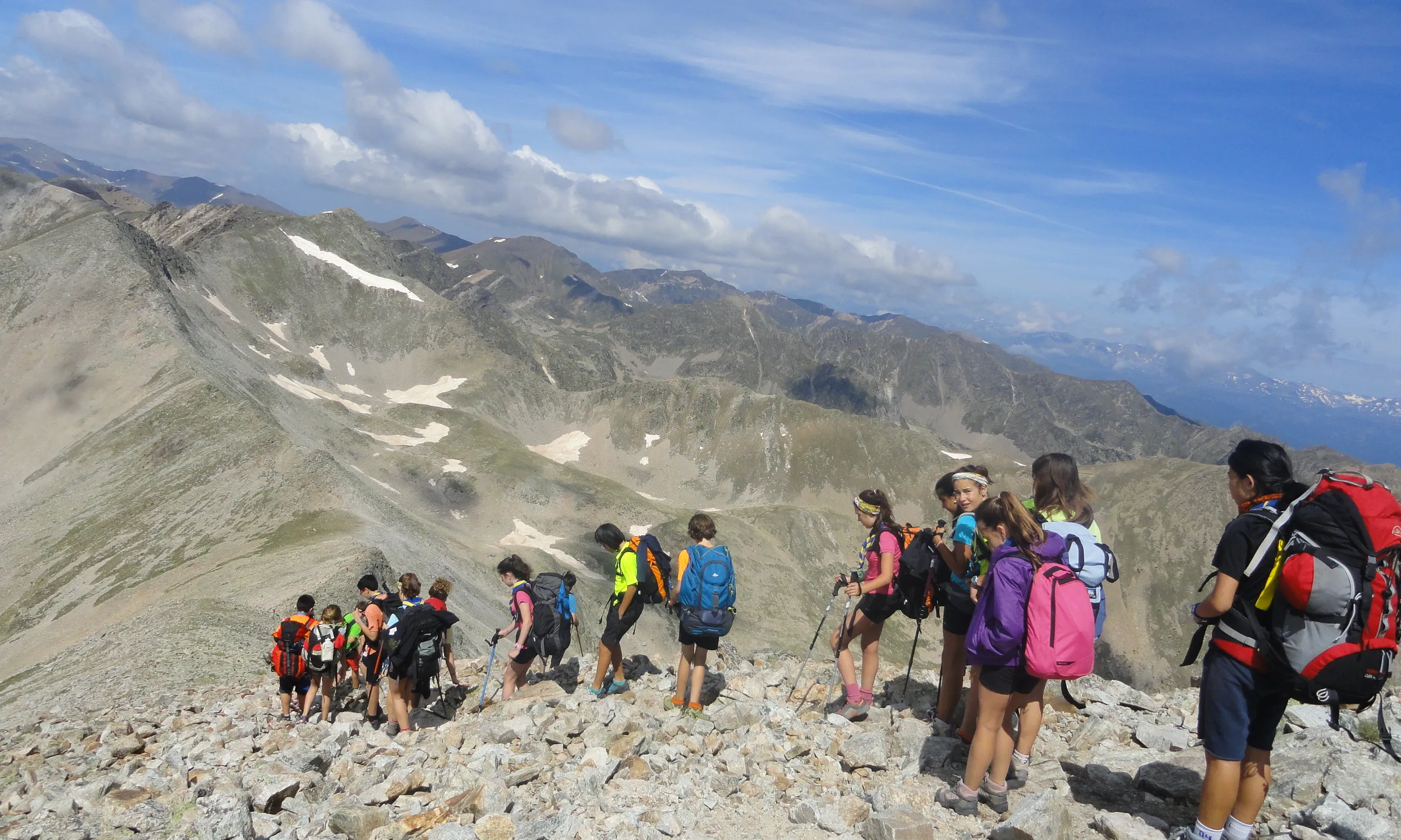 Un grup d'escoltes de ruta en el cim d'una muntanya.