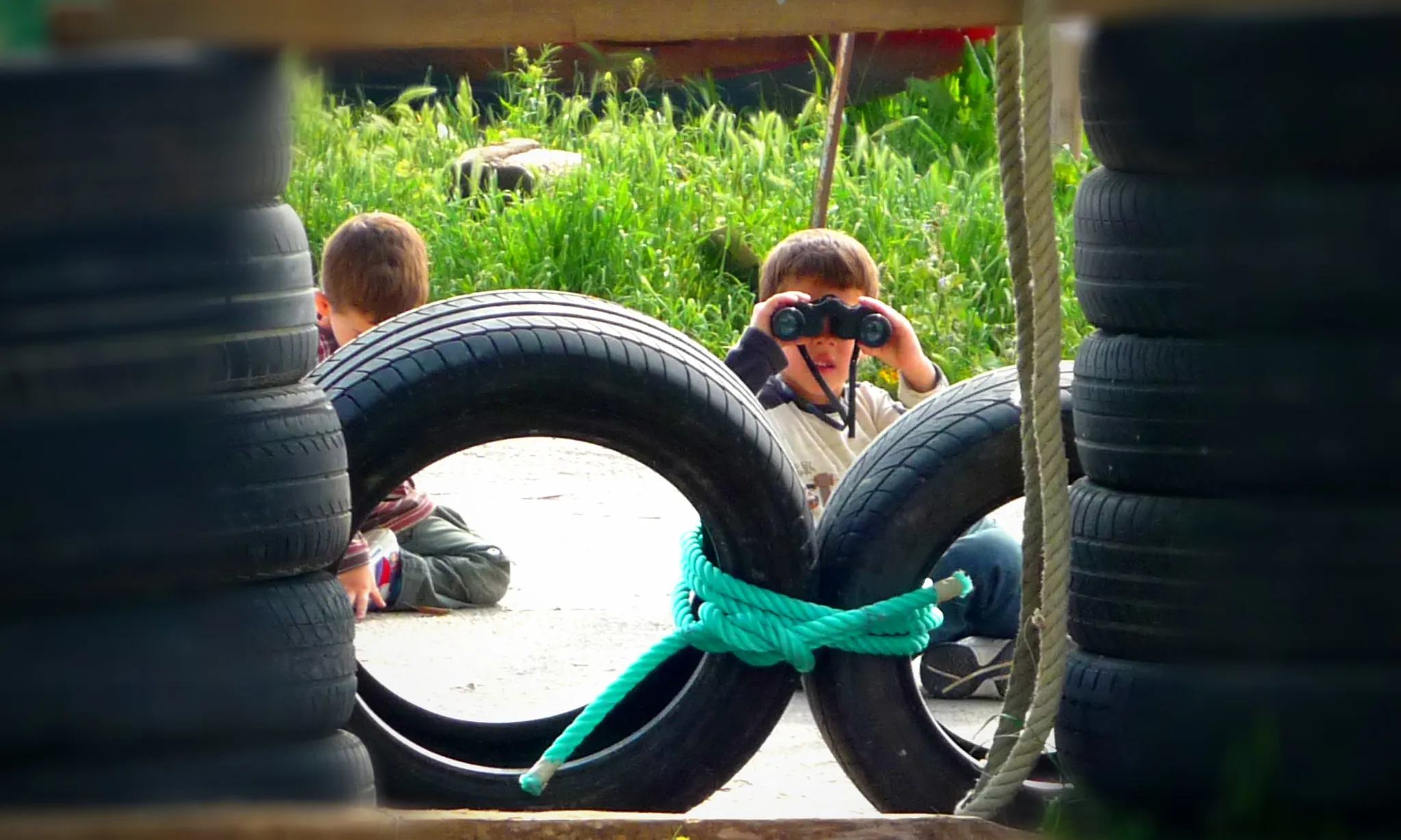 Nen mirant amb primsàtics en un parc