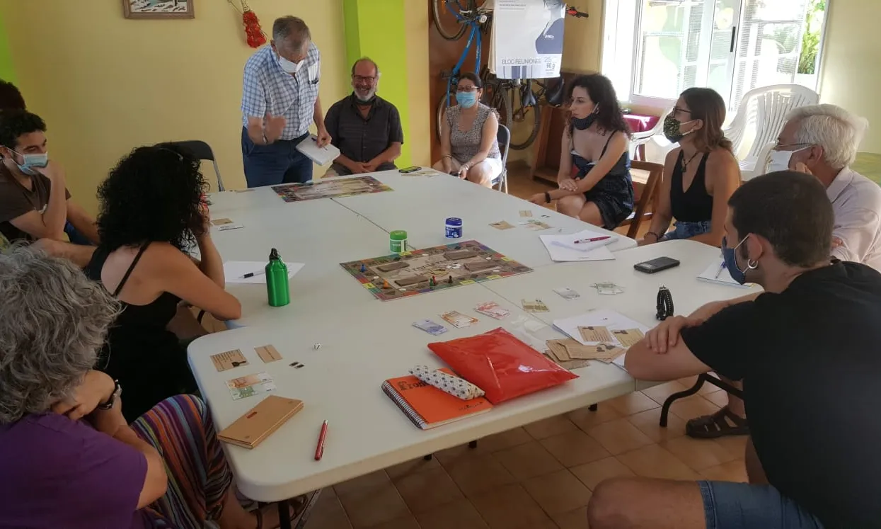 Persones al voltant d'una taula jugant amb un joc de taula