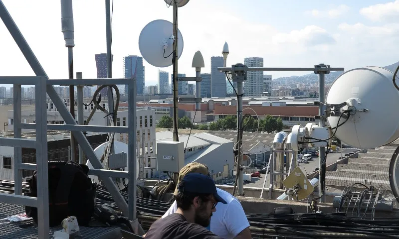 Fotografia d'uns voluntaris d'eXO.cat treballant en una instal·lació d'una antena de Guifi.net. Imatge de Victor Oncins.