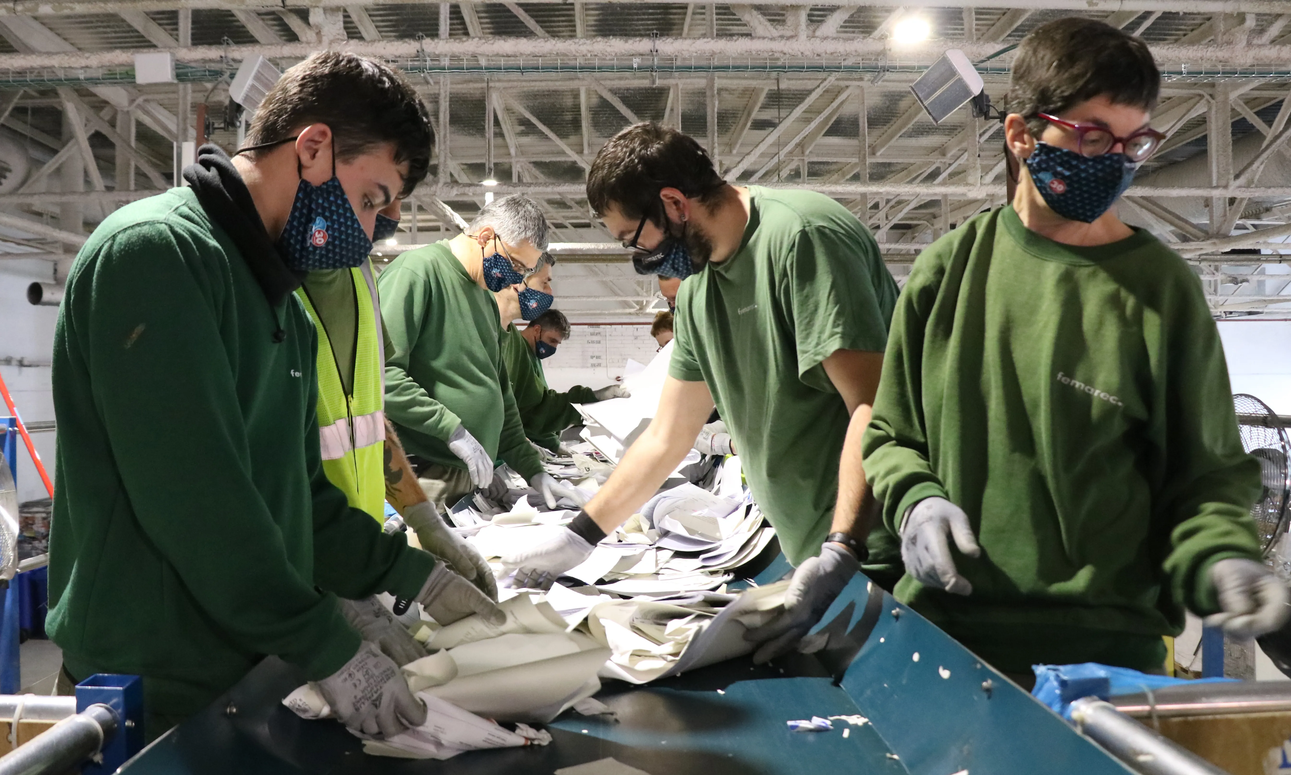 Persones treballadores del Centre Especial de Treball a la cinta de triatge de la secció de Gestió de Residus