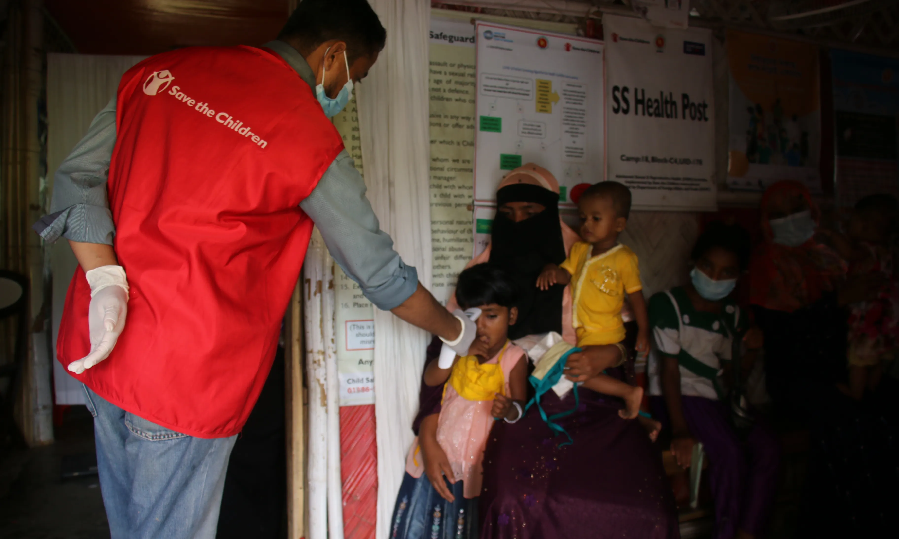 Un dels treballadors humanitaris de Save The Children a Bangladesh, atenent una família de pacients regulars al centre de salut primària de Save the Children al camp de refugiats de Rohingya.