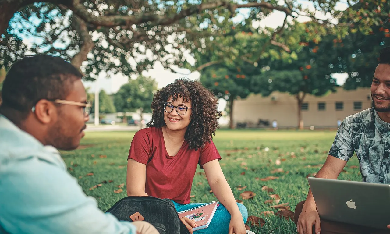 Persones estudiant a la gespa. Font: Pixabay