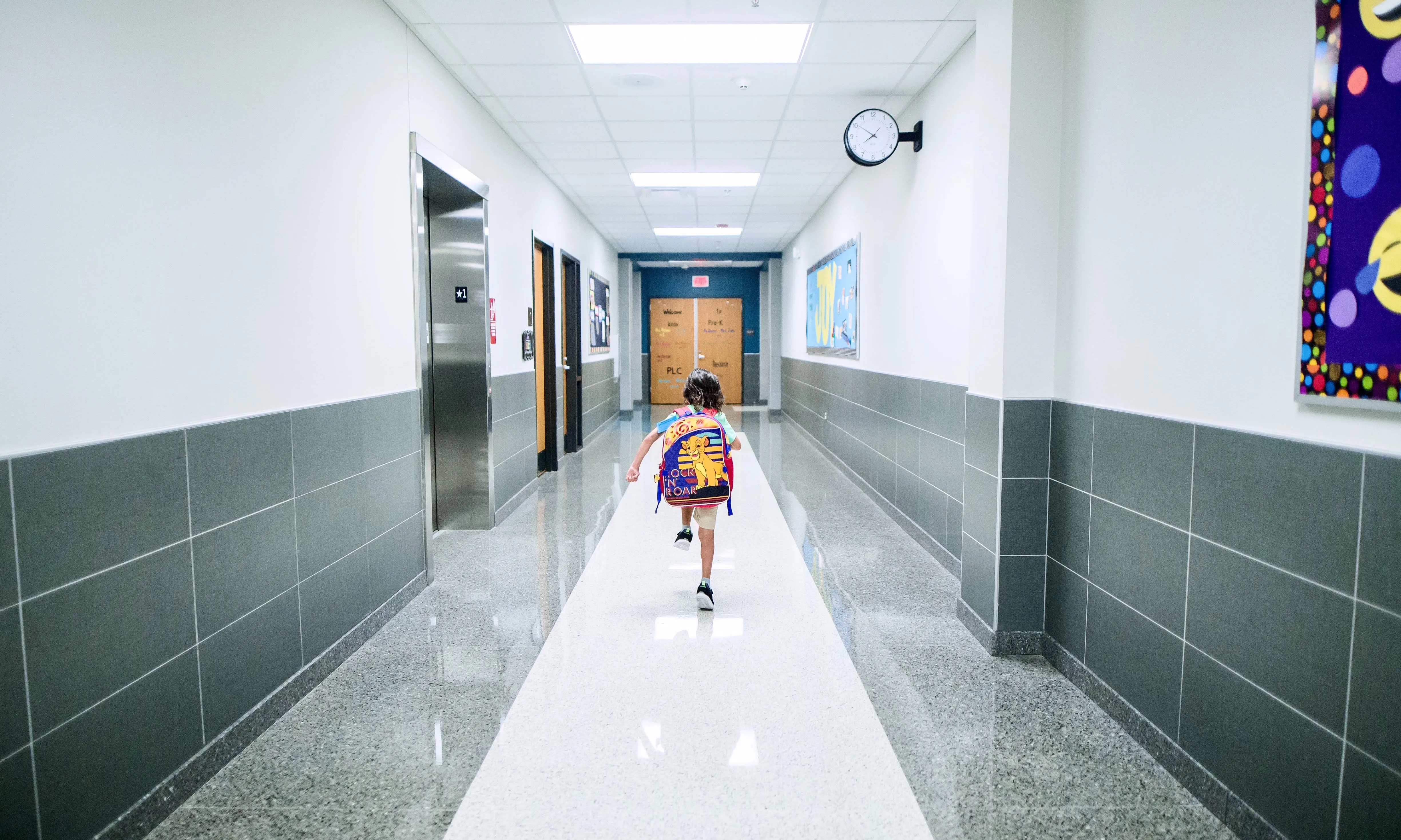 Infant corrent en un passadís d'escola. Font: Pexels - Caleb Oquendo