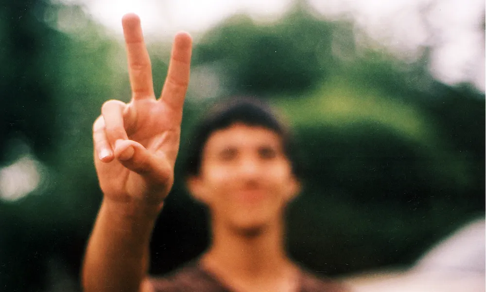 Noi fent el símbol de la pau en primer pla