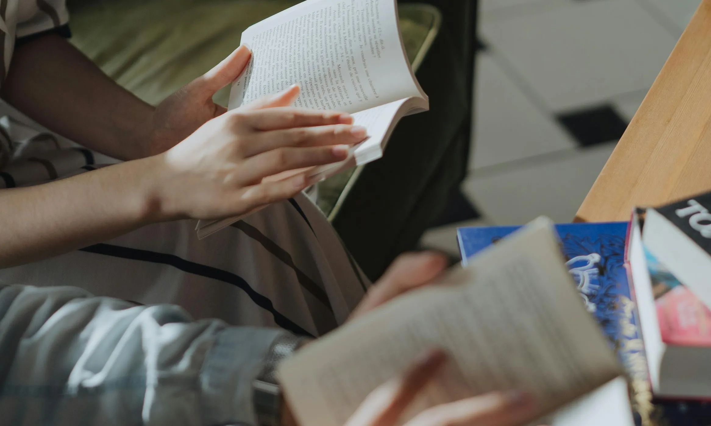Persones llegint un llibre. Font: Pexels - Cottombro Studio