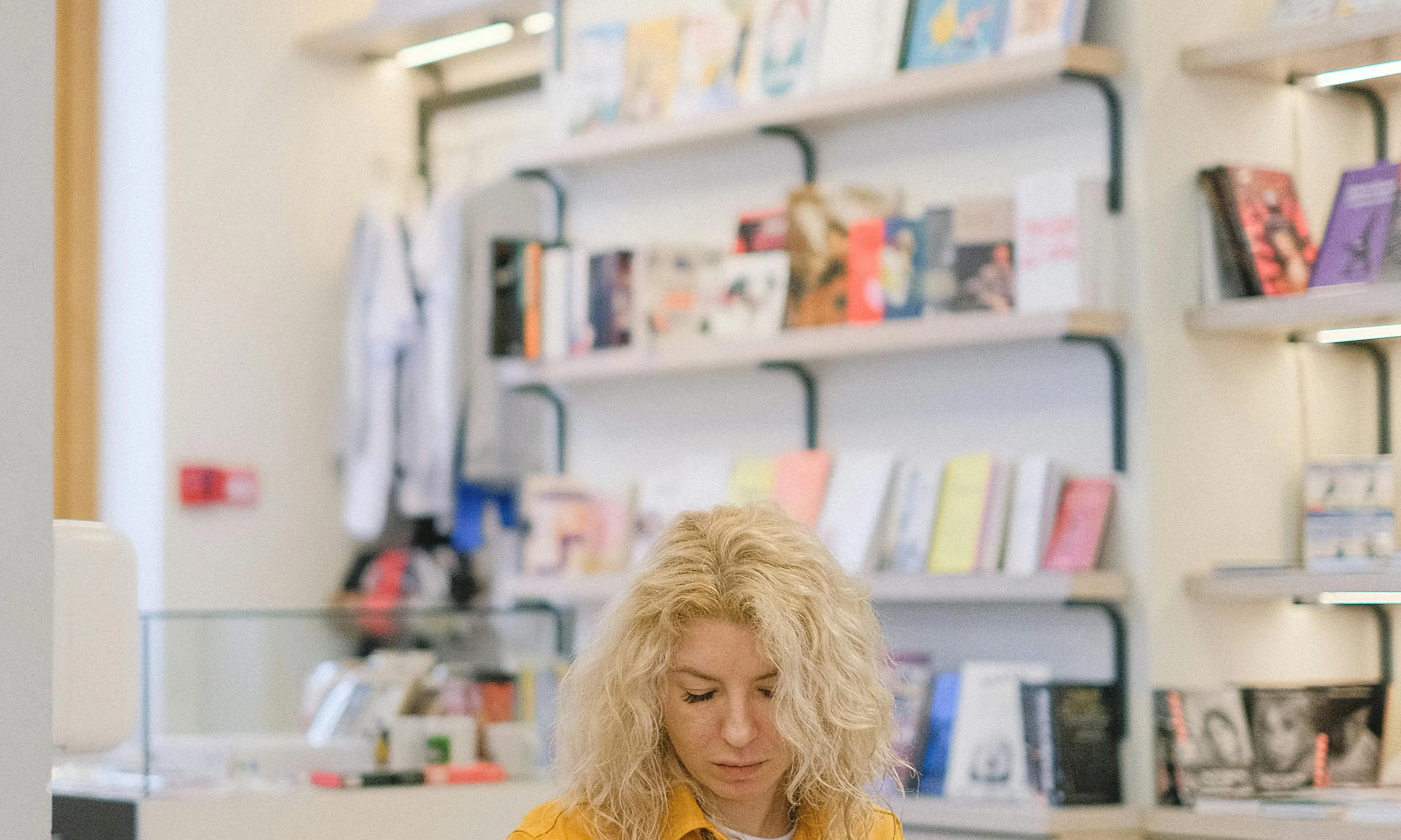 Noia en un stand de llibres. Font: Pexels - SHVETS production 