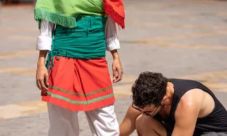 Noi ajudant a una noia a cordar les espardenyes. Font: Niu d'imatges de la joventut