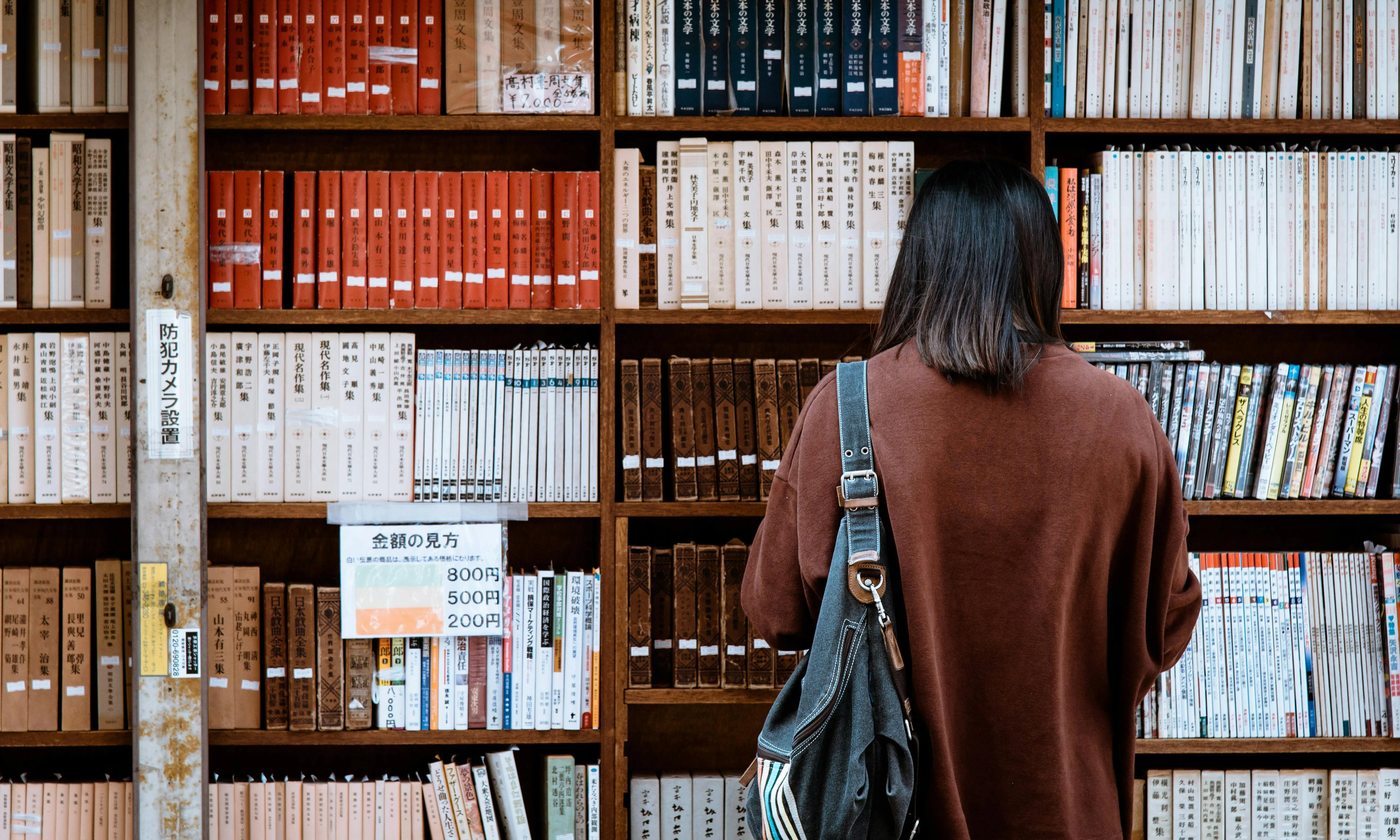 Persona consultant una biblioteca històrica. Font: Pexels - Abby Chung