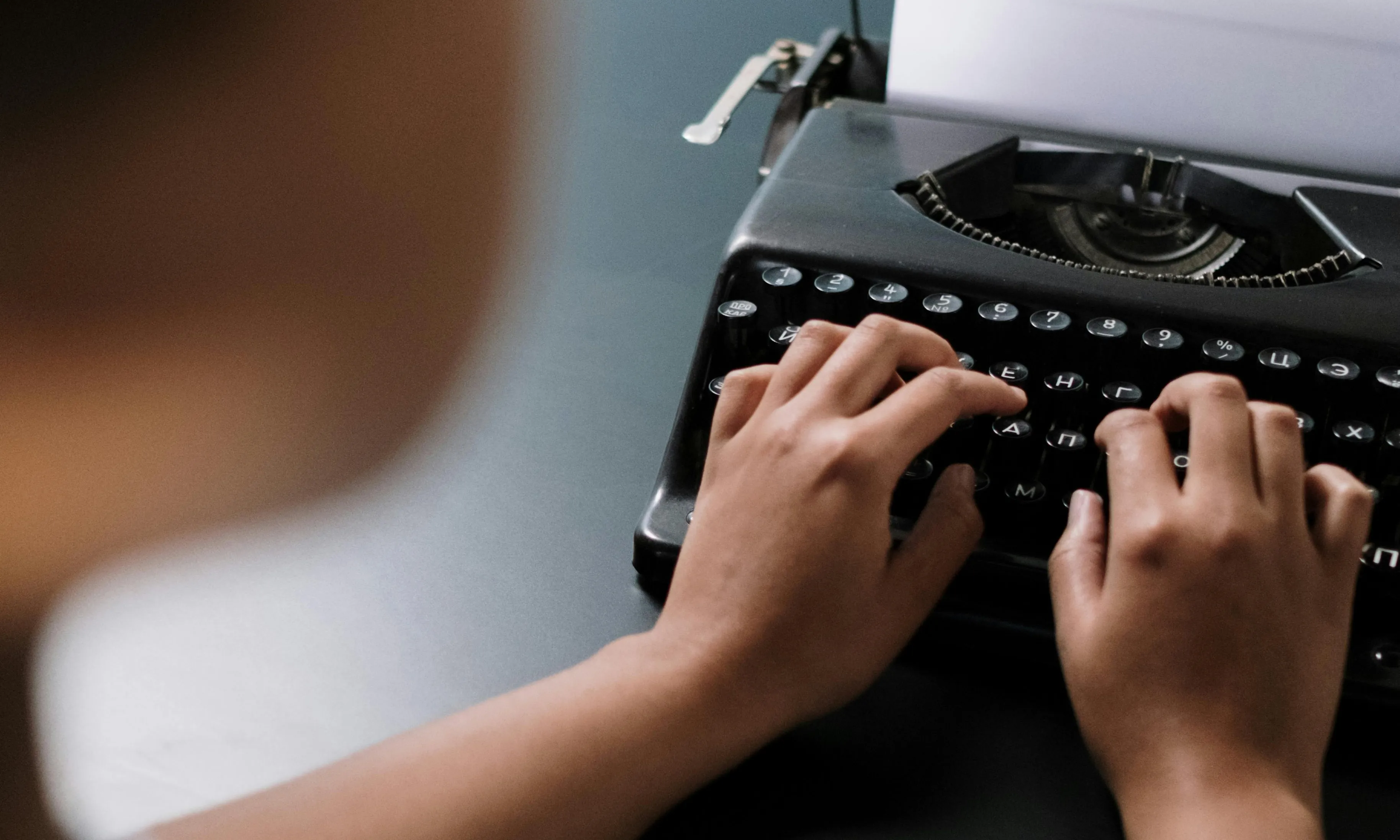 Persona escrivint amb una màquina d'escriure. 