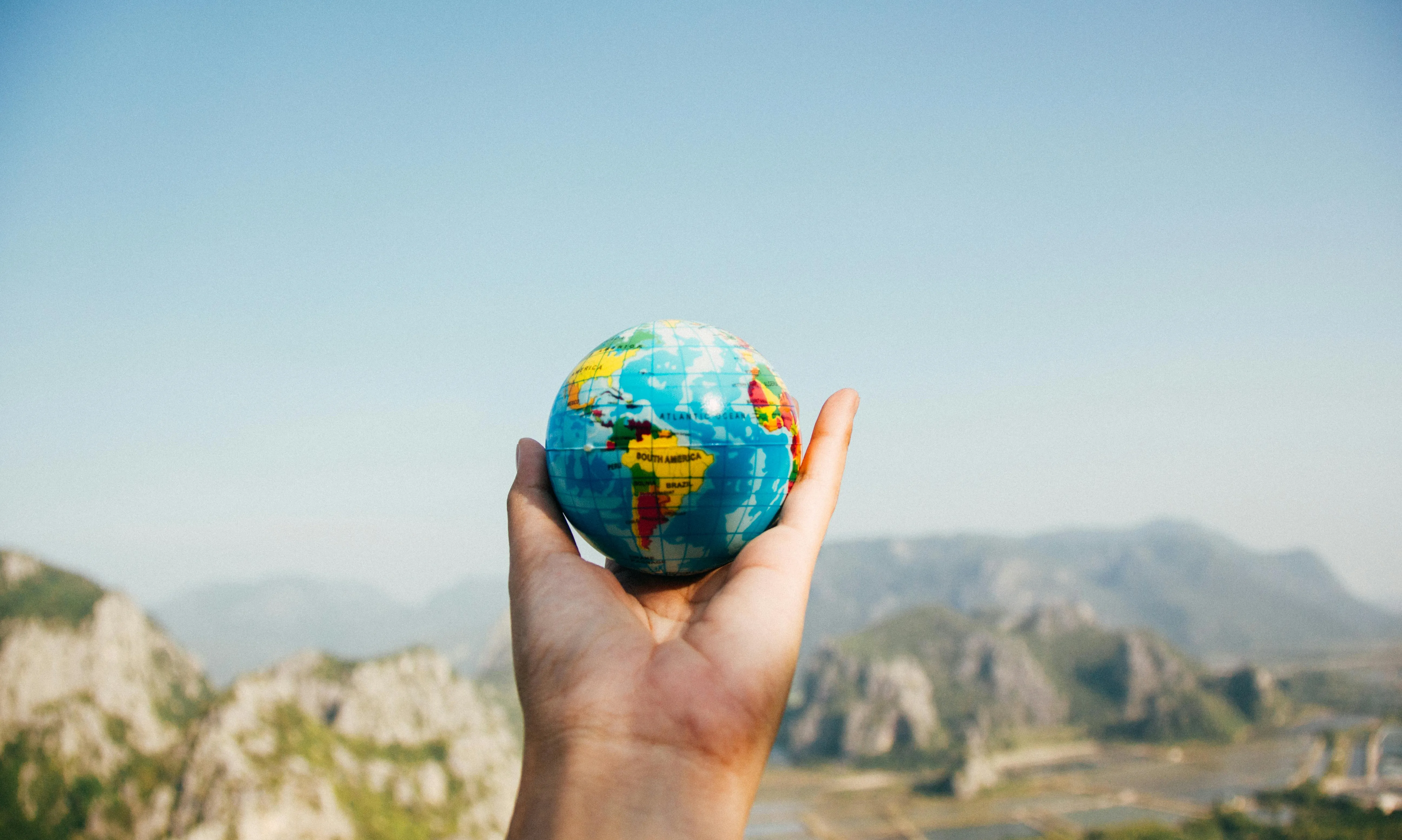 Mà sostenen un globus terraqüi. Font: Pexels - Porapak Apichodilok