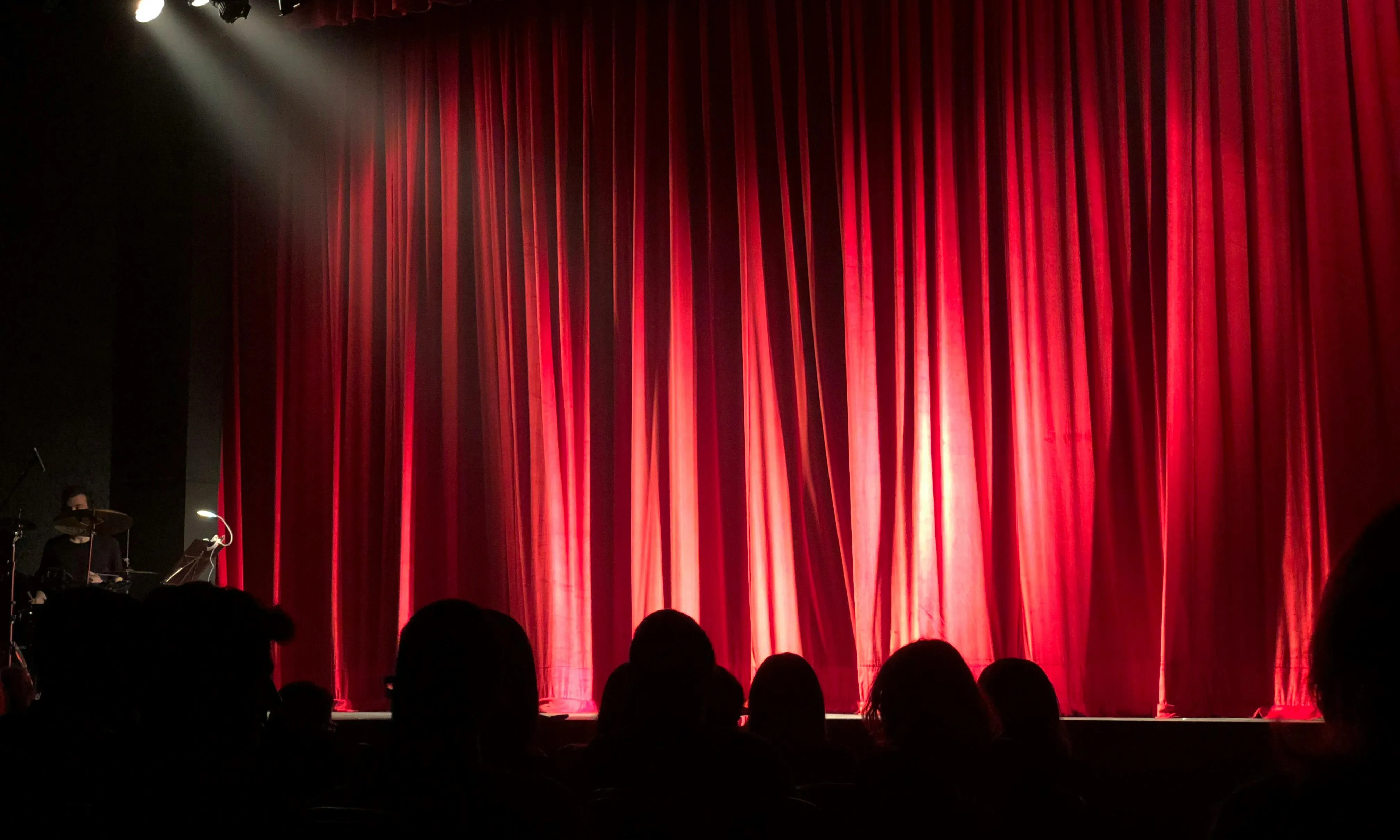 teló tancat i caps de persones, esperant que comenci l'espectacle. Font: Pexels - Monica Silvestre