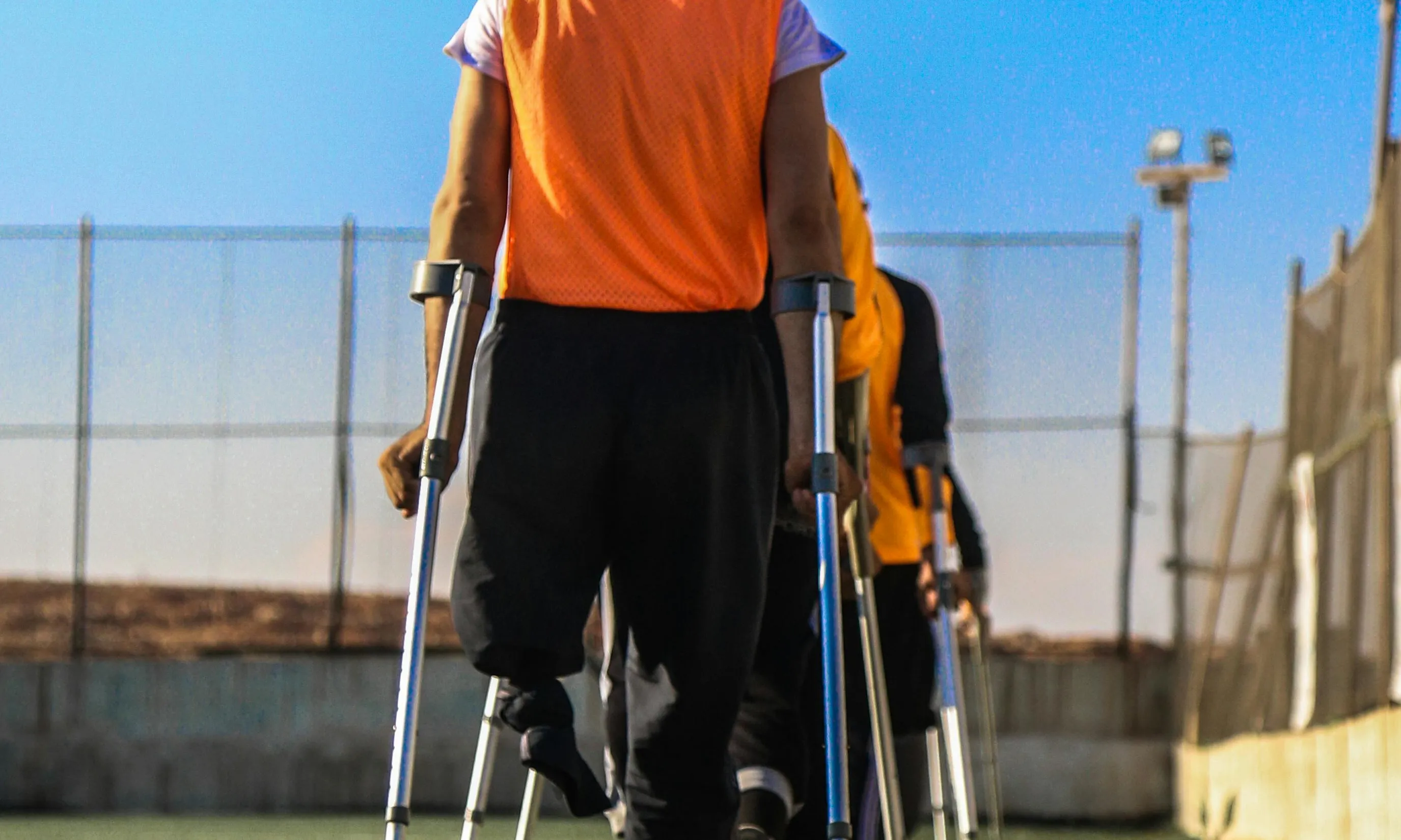 Persones amb croces en un camp de fútbol. Font: Pexels - Anas Aldyab