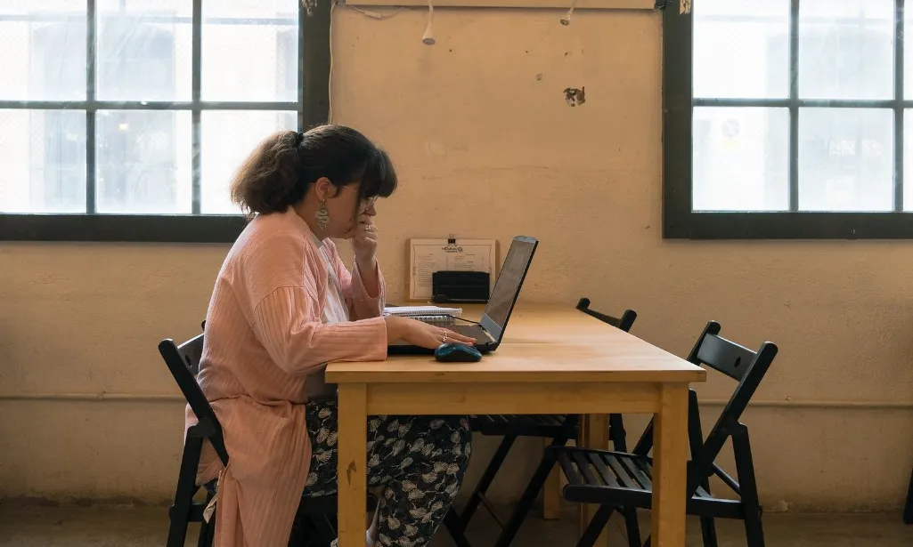 Persona jove treballant en un ordinador, presentant un projecte.