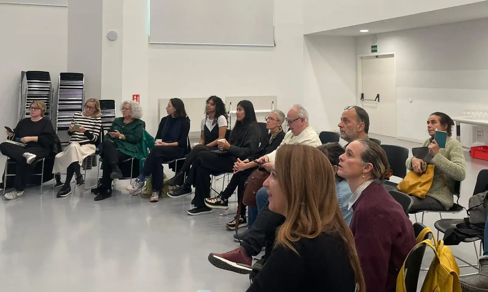 Persones assegudes en una sala escoltant propostes culturals