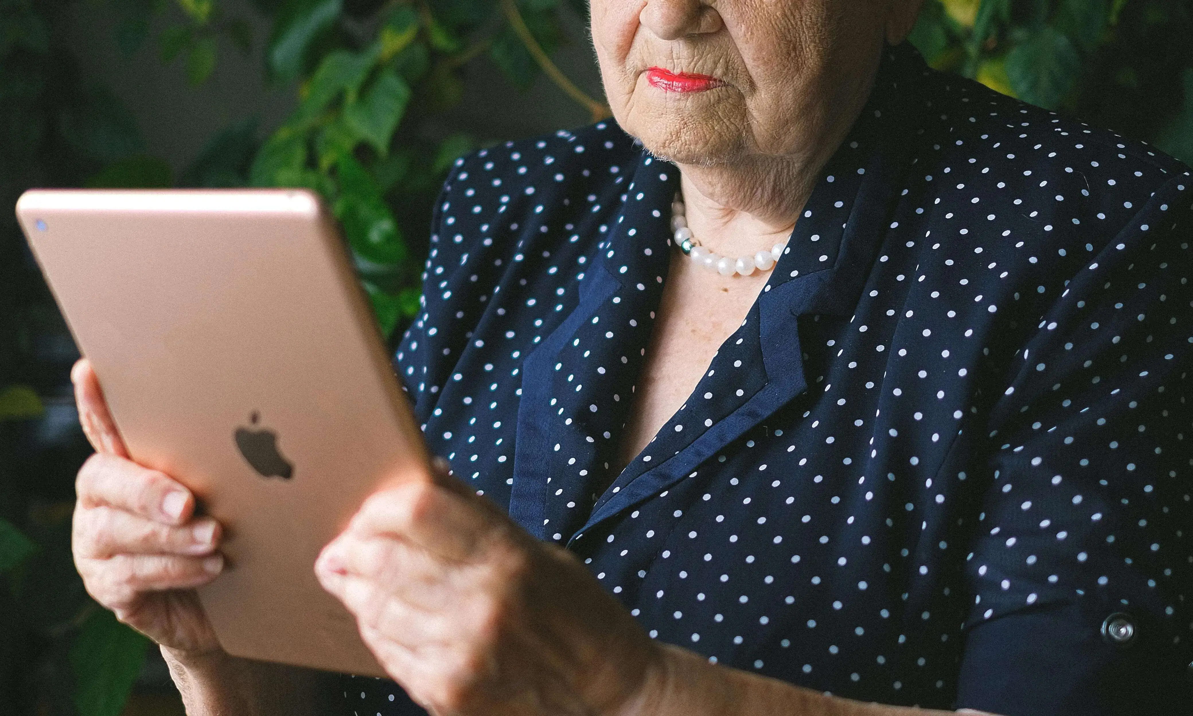 Senyora gran mirant una tauleta com si llegís 