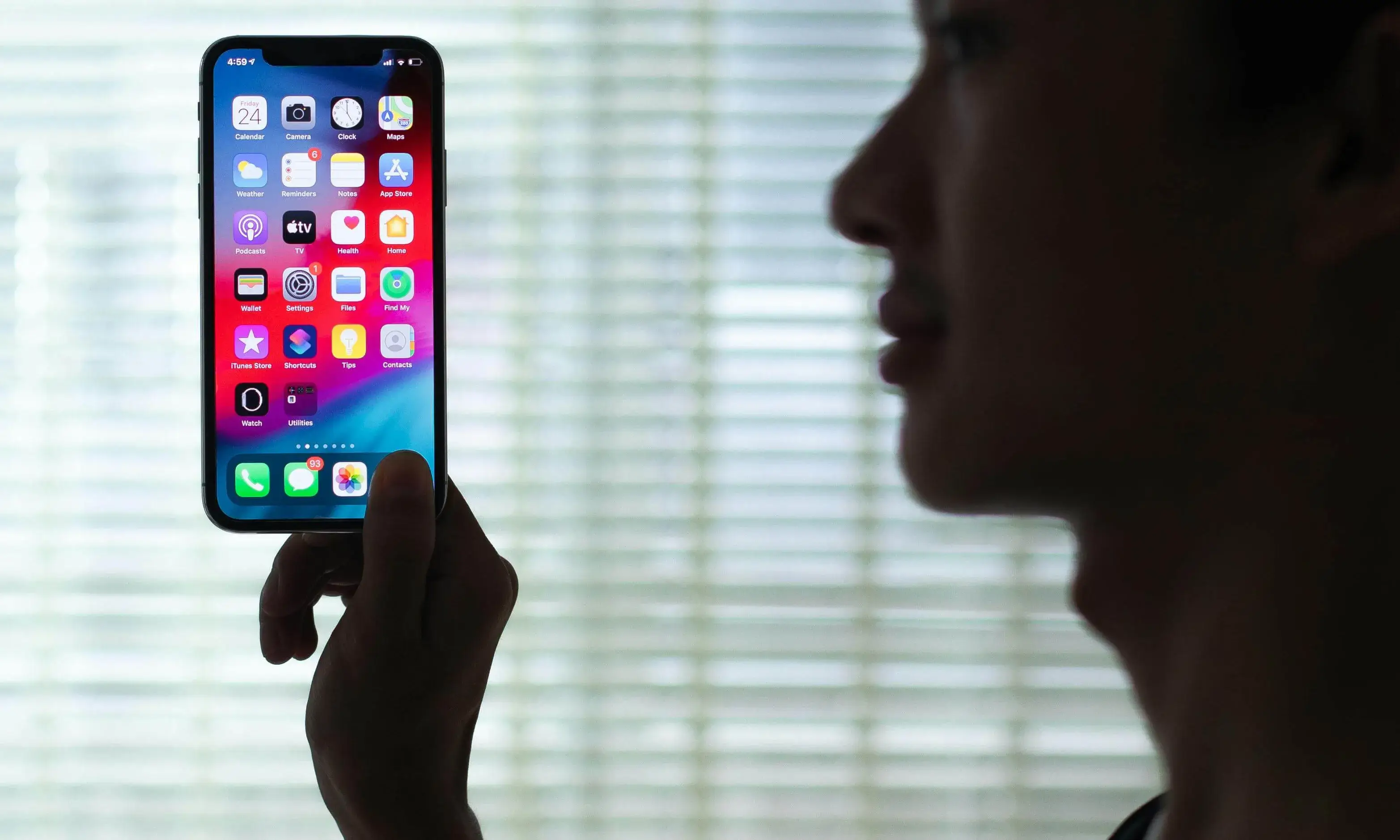 Silueta d'una persona subjectant un telèfon encès