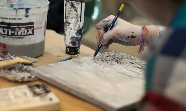 Persona dibuixant amb diferents materials d'art
