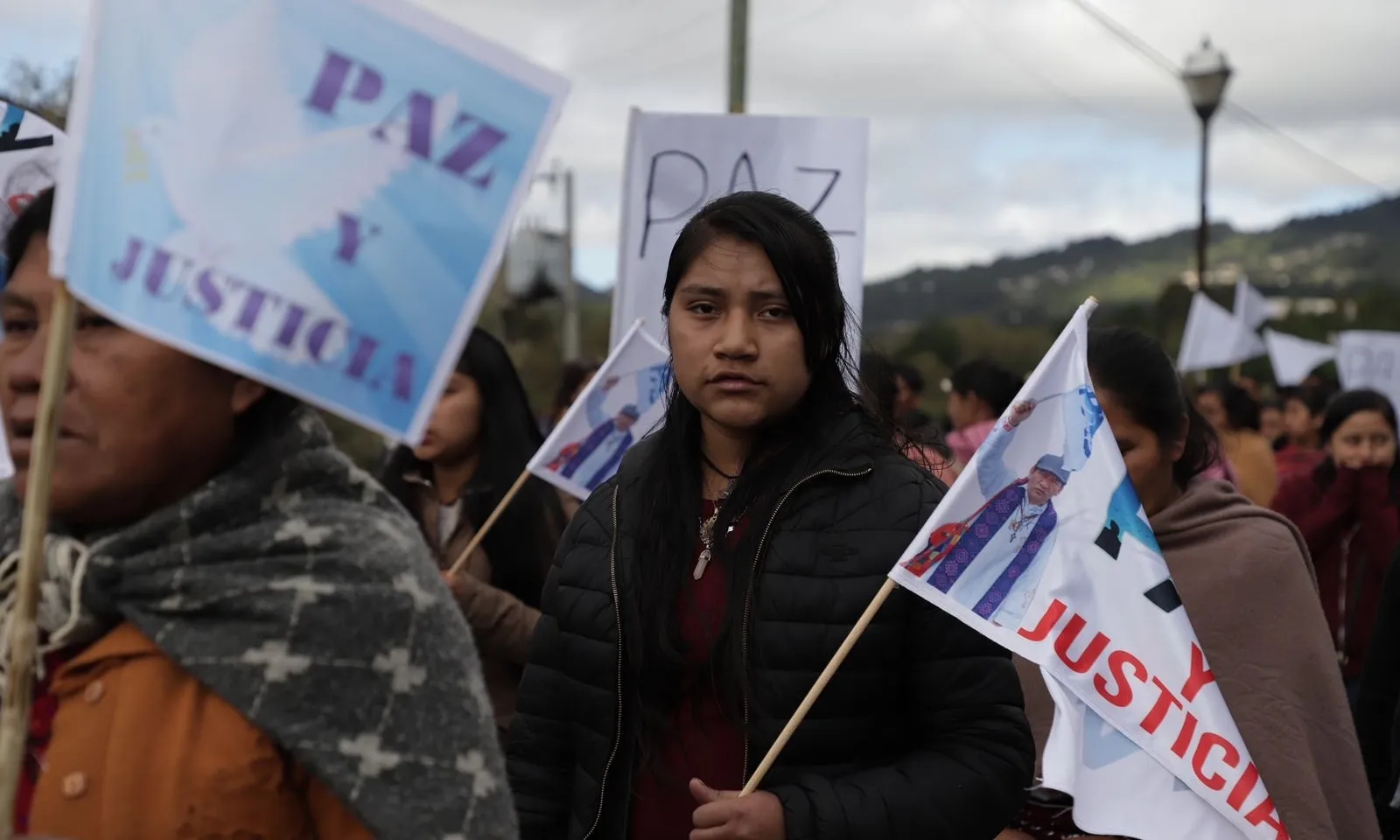 Una noia mirant directament a càmera amb cara consternada enmig d'una manifestació a favor dels drets humans dels pobles indígenes mexicans.