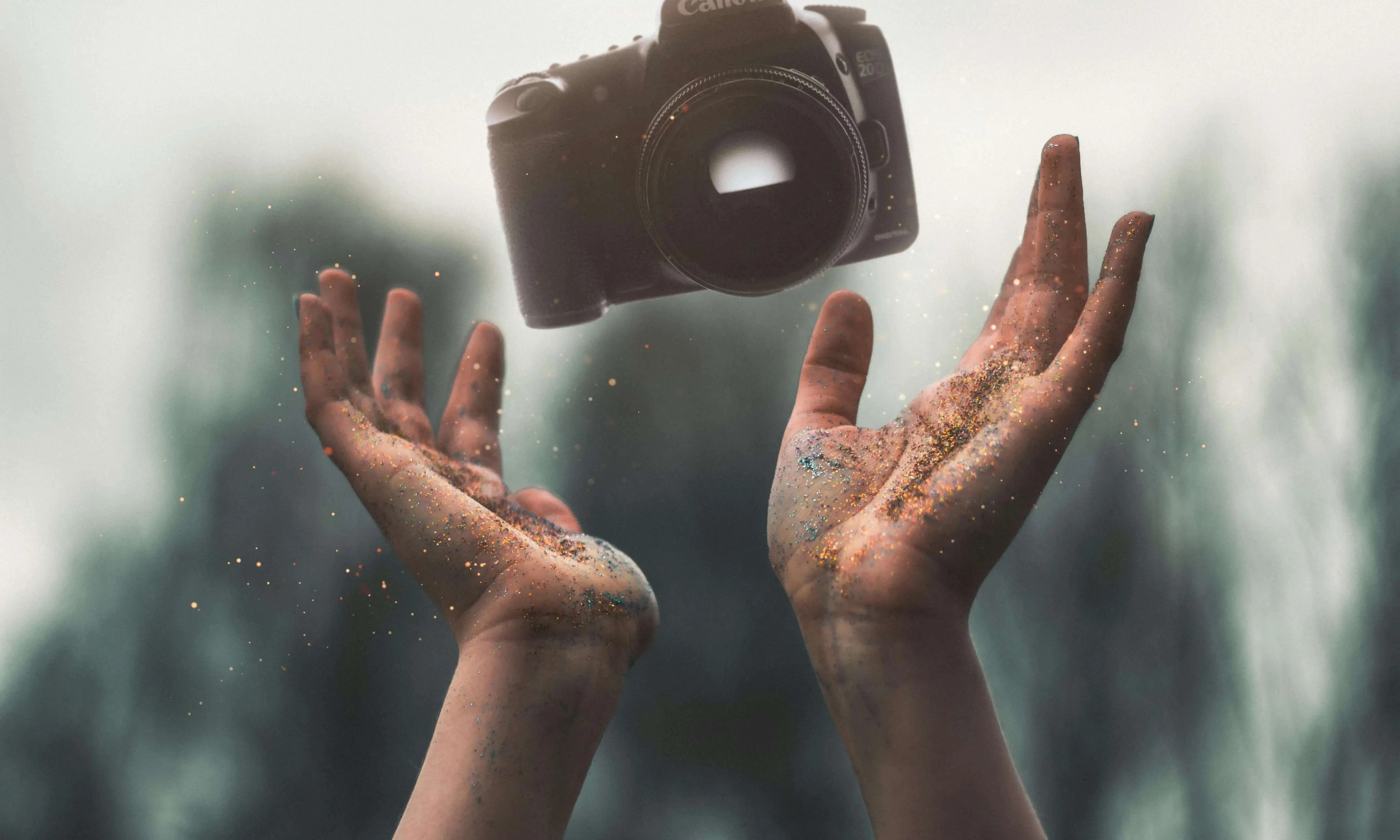 Mans plenes de sorra tirant enlaire una càmera de fotografiar Mans plenes de sorra tirant enlaire una càmera de fotografiar