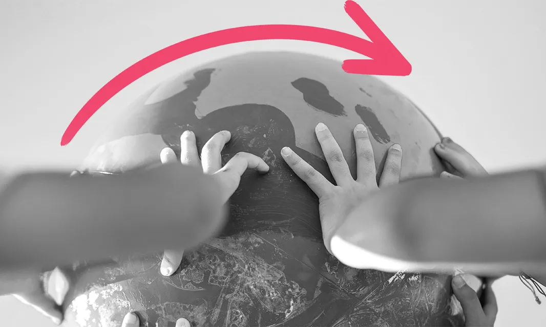 Mans fent l'acció de girar un globus terràqui