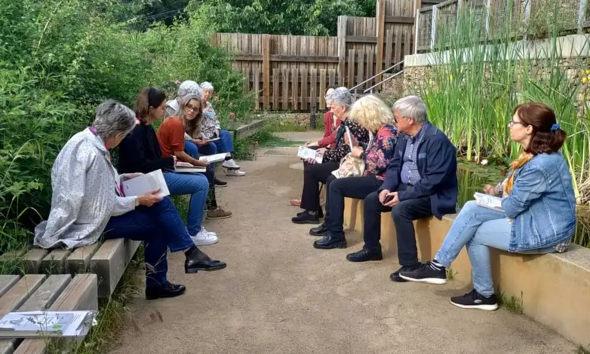 Fotografia de l'anterior lectura al bosc amb el grup de participants compartint reflexions a la vora de la bassa naturalitzada del Bosc Turull.