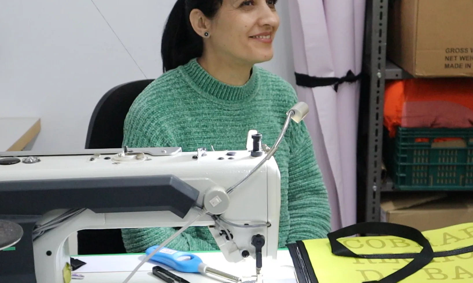 Una persona cus amb una màquina de cosir en un taller de reutilització tèxtil del Centre de Promoció Social Francesc Palau.