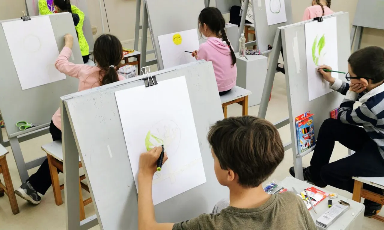 Un grup de nens participant activament en activitats de dibuix durant una classe d'art.