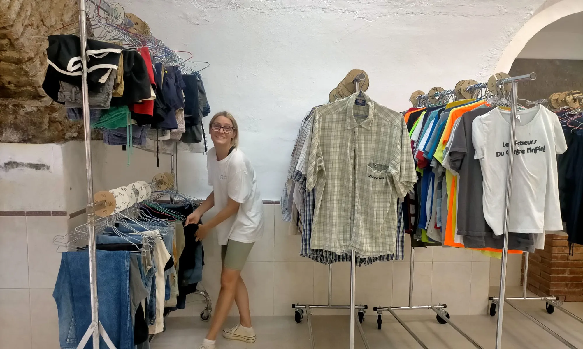 Una fila de camises i samarretes penjada en un penjador.